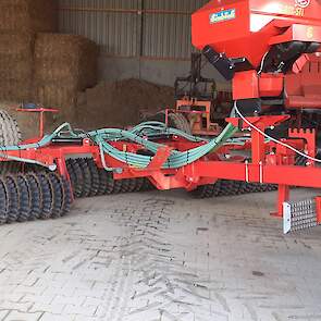 Achter de trekker hangt een zaaimachine en een rol. Deze rol drukt het graszaad in de grond, waardoor het uiteindelijk makkelijker kiemt. De vorm van het uiteinde van de rol heeft veel weg van een schapenhoef en draagt daarmee bij aan het uitstoelen van h