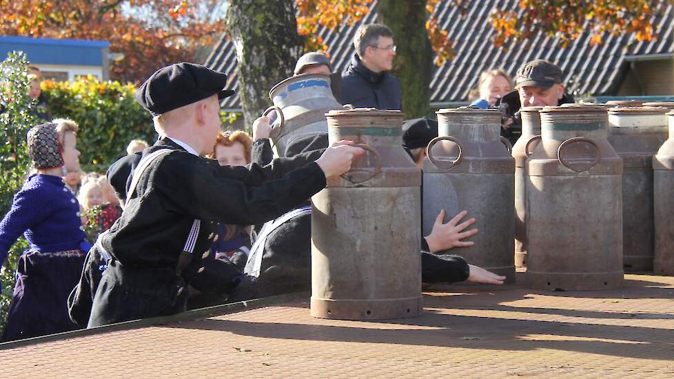 Bij een van de scholen zijn kinderen in klederdracht gehuld. De jongens mogen de bussen op de wagen zetten.