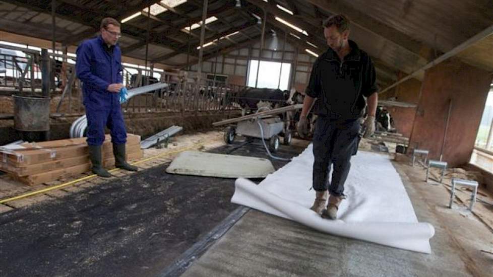 Een beschermlaagje wordt over het beton uitgerold. Dat Folkertsma tegelijk met de matras zijn boxinrichting vervangt, vergemakkelijkt het werk.