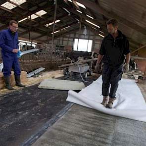 Een beschermlaagje wordt over het beton uitgerold. Dat Folkertsma tegelijk met de matras zijn boxinrichting vervangt, vergemakkelijkt het werk.