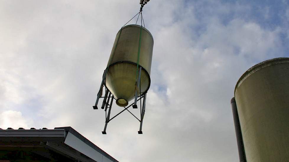 Ergens tussen de oude en nieuwe stal bungelt een silo.