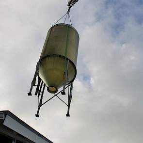 Ergens tussen de oude en nieuwe stal bungelt een silo.