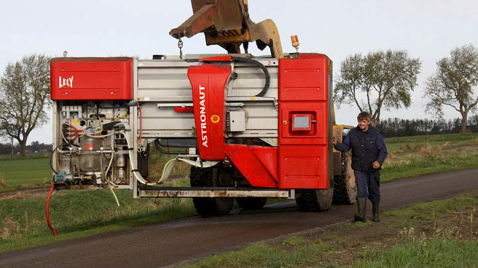 Als een vis op het droge hangt een melkrobot in een shovel.