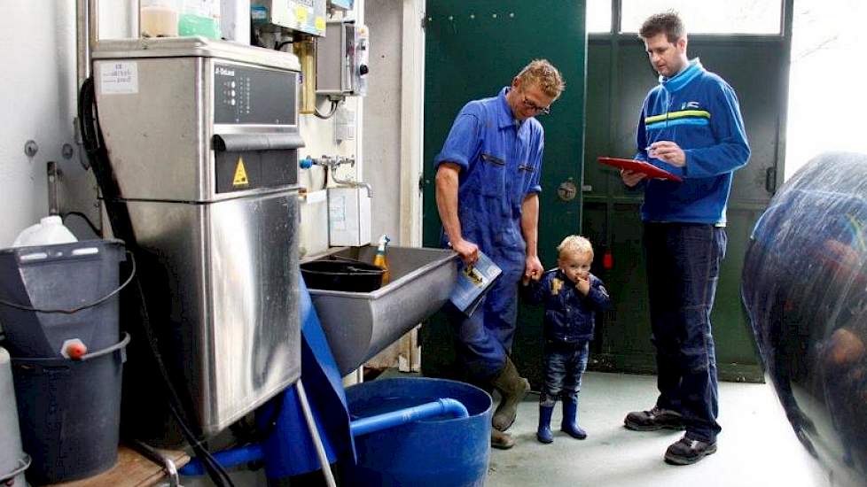 Controleur Gerco Berger in gesprek met Klaas Hoogendoorn bij de reinigingsinstallatie van de melkmachine.