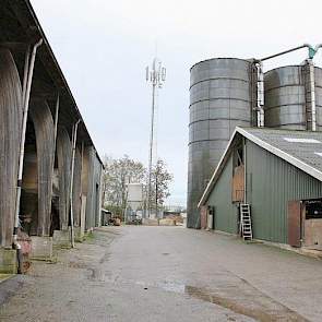 Rechts is de achterkant van de oude stal te zien, links de flinke werktuigenberging met karakteristieke houten spanten. Achter zijn duidelijk de drie grote torensilo's te zien.