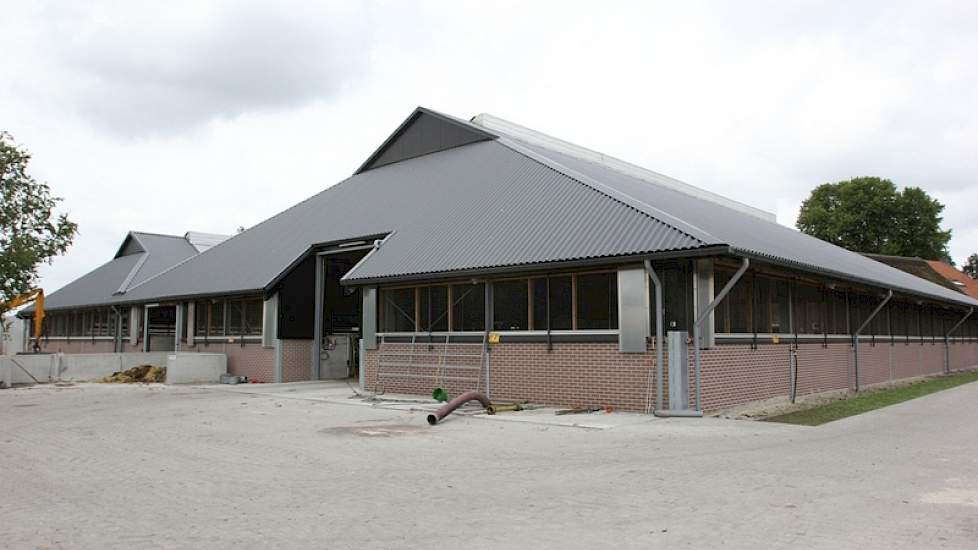 De achterkant van de 6+2 rijige ligboxstal met het karakteristieke zadeldak. De onderbouw van de oude stallen is helemaal blijven staan.