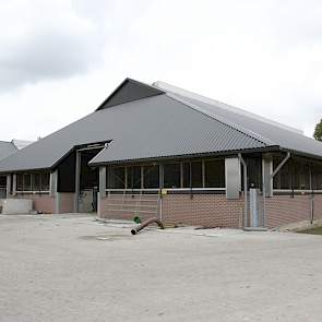 De achterkant van de 6+2 rijige ligboxstal met het karakteristieke zadeldak. De onderbouw van de oude stallen is helemaal blijven staan.