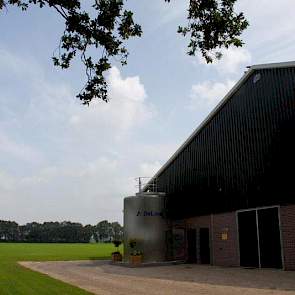 Het vooraanzicht van de stal met de vertikale silotank.