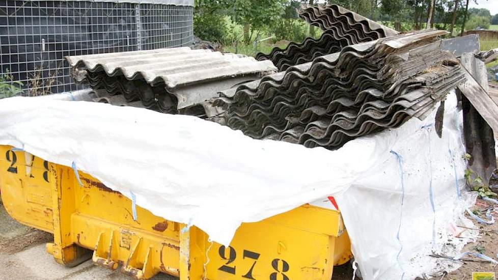 De oude asbestvrije golfplaten gaan in de container.