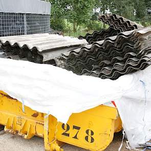 De oude asbestvrije golfplaten gaan in de container.