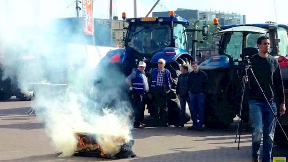 Een brandende strobaal moet het protest kracht bijzetten.